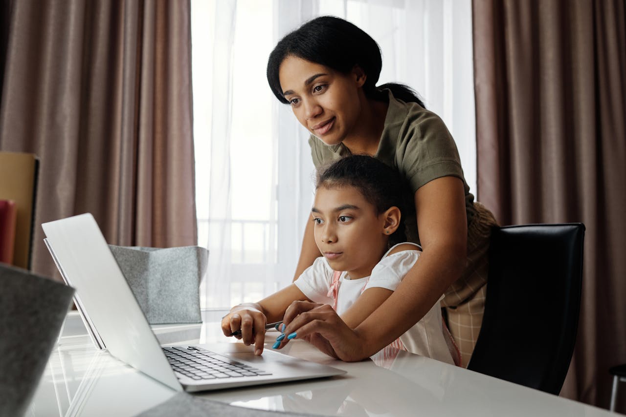 mother helping her daughter in online learning